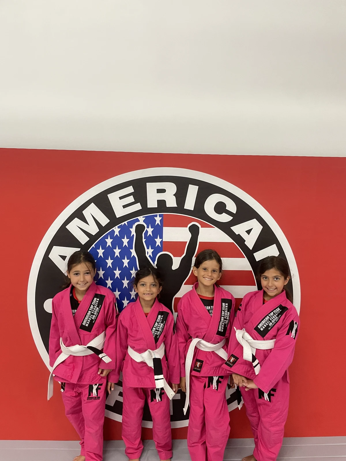 Group of young Brazilian Jiu-Jitsu students smiling with their belts at ATT Winter Garden